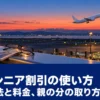 夕方の空港の展望デッキから見える離陸する旅客機と、手すりに置いた搭乗案内と老眼鏡